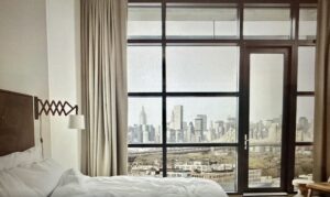 A bedroom with a view of the city.