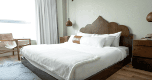 A bed with white sheets and pillows on it