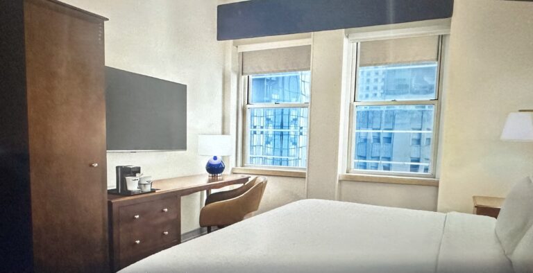 A bedroom with a desk and television in it