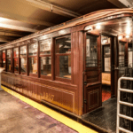 A trolley car is parked in a subway station.