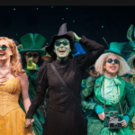 A group of people in green costumes on stage.