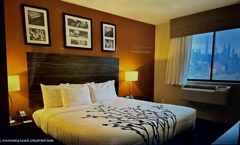 A bedroom with a bed, lamps and pictures on the wall.